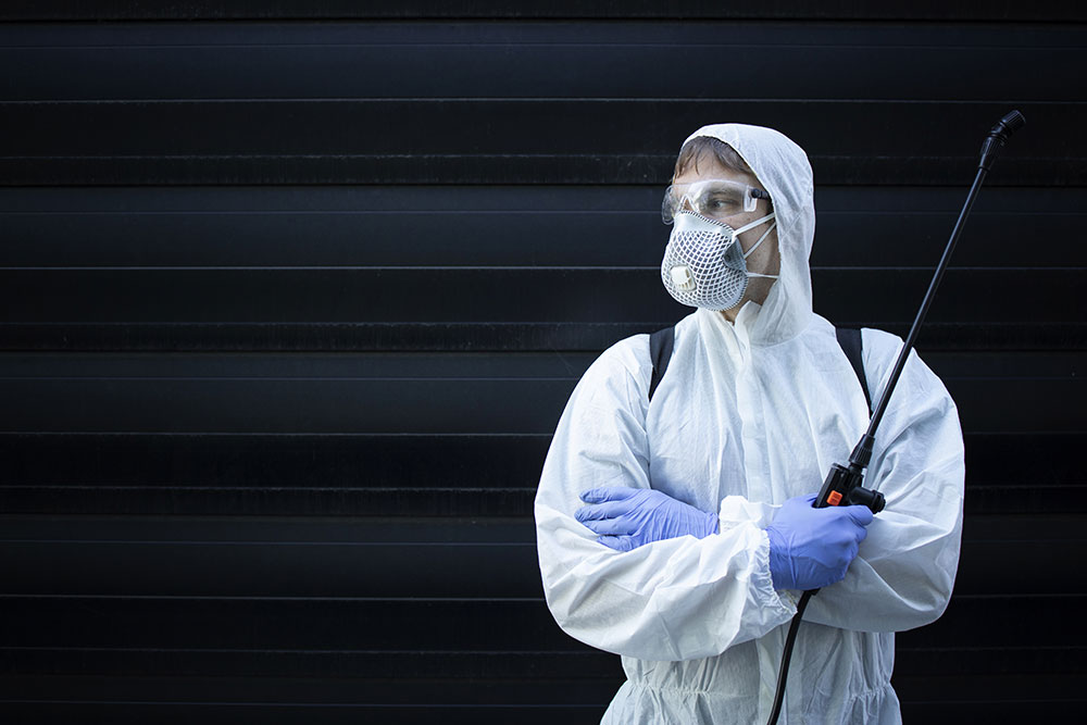 Portrait of professional exterminator holding sprayer with chemi